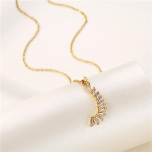 Elegant gold necklace with a curved crescent pendant set with clear rectangular gemstones