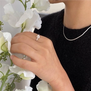 Detail of elegant 925 silver pearl ring and matching snake chain necklace on model