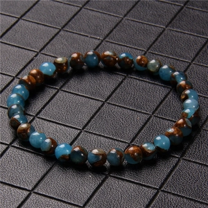 Macro detail of 6mm natural stone beads with unique blue-brown textures and earthy tones
