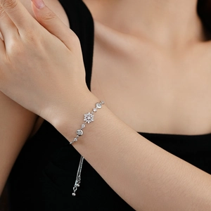 Détail du bracelet flocon de neige réglable serti de zircons sur un poignet féminin