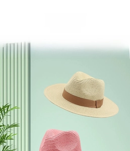 Dettaglio di cappelli di paglia stile Panama beige e rosa con nastri decorativi