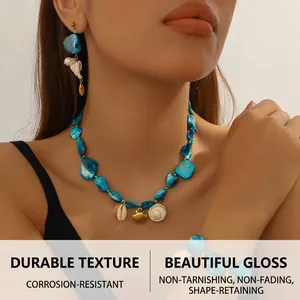 Macro view of blue shell and pearl jewelry set with conch charms for summer beach style