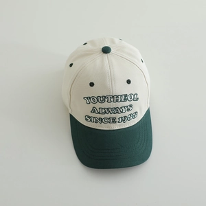 Detail view of the embroidered YOUTHEOL lettering on a two-tone cotton baseball cap