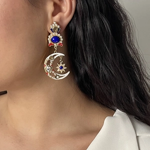 Dettaglio di orecchini vintage con nappa sole e luna con perle e strass blu