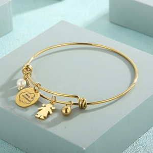 Détail d'un bracelet extensible doré avec pendentif de Noël et accents de perles