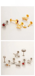 Macro display of titanium labret studs in gold and silver with zircon heart and snake motifs