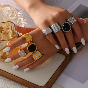 Luxe gold and silver titanium rings with black agate and pavé diamonds on a model hand
