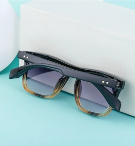 Detail of vintage square black sunglasses with gradient lenses and gold star rivets