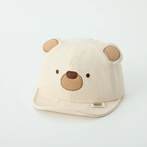 Dettaglio del berretto in cotone beige per neonato con orecchie da orso 3D