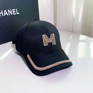 Detail of black baseball cap with crystal-embellished M logo and colorful rhinestone rim