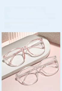 Close-up of pink and clear oversized glasses frames with metallic details on temple
