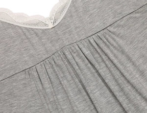 Close-up of V-neck grey modal nightgown with delicate white lace trim and pleated detail