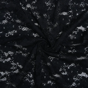 Close-up of black floral lace fabric texture showing intricate hollow patterns and knots