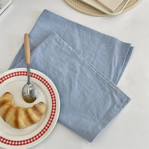 Minimalist solid blue linen-textured heat-resistant placemat on white table