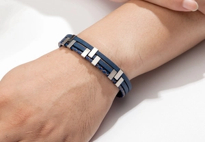 Close-up of men's layered blue braided leather bracelet with polished metal accents