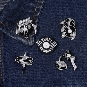 Set of 5 retro skull and music enamel pins pinned on a blue denim jacket pocket