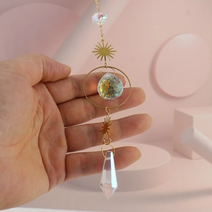Detail of crystal suncatcher with golden sun hoop and faceted crystal ball drop