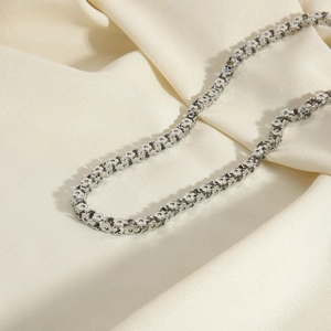 Polished silver stainless steel textured link chain necklace on soft silk fabric