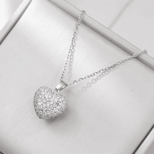Detail view of heart pendant necklace with shimmering paved white crystals on silver chain