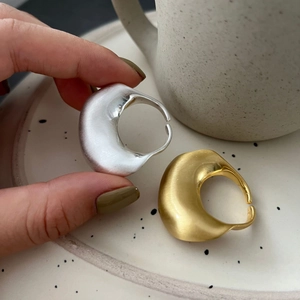 Artistiek detail van goud en zilver onregelmatige geborstelde brede ringen op tray