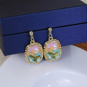 Macro detail of French vintage square enamel earrings with colorful gradient and pearls