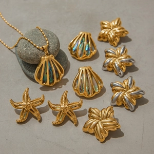 18K gold stainless steel necklace with ocean shell and starfish charms on stone surface