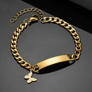 Macro detail of gold Cuban chain bracelet featuring custom engravable bar and butterfly charm