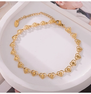 Macro view of gold heart chain links with textured engraving and S.STEEL stamp