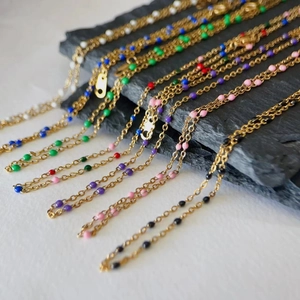 Macro shot of 18k gold plated titanium necklaces with multi-colored enamel beads