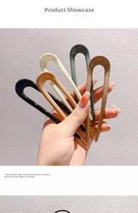 Close-up of five U-shaped hair pins in black, green, beige, pink and brown resin