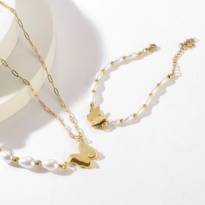Nahaufnahme des goldenen Schmetterlings-Schmucksets mit Perlen und matter Textur