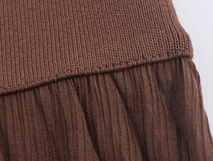 Dettaglio della maglia a coste e del tessuto a pieghe su un abito marrone elegante
