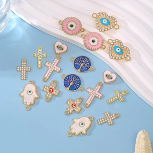 Mix of 10 evil eye and cross alloy charms for bracelets on a light blue background