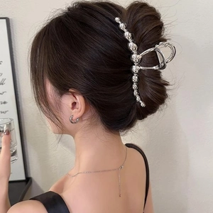 Minimalist silver metal hair claw clip with bubble design worn by model from side view