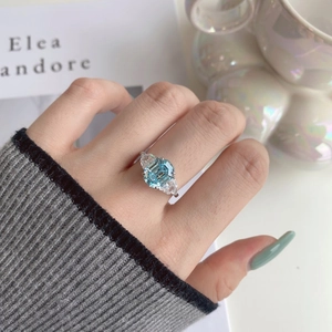 Detailed view of S925 silver ring featuring blue rectangular zircon and side stones on finger