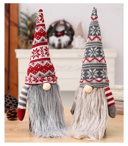 Detail of Christmas gnomes with knitted jacquard hats and long faux fur beards on a cozy desk