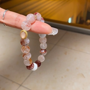 Macro shot of red phantom quartz beaded bracelet with gold accent and natural textures