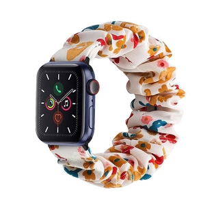 Detail of floral scrunchie watch band with red and blue patterns on blue smartwatch