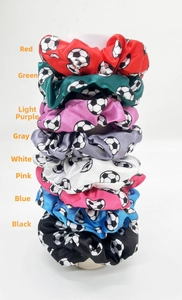 Close-up of eight colors of satin soccer print hair scrunchies on a display stand