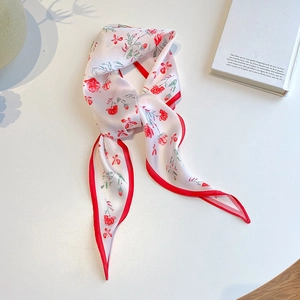 Detailed macro view of floral twilly silk scarf with red roses and elegant satin texture