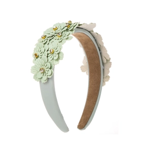 Close-up of light green floral headband with crystal accents and 3D petal texture
