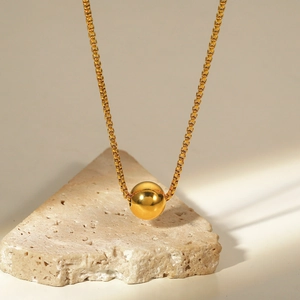 Detailed close-up of a 18K gold-plated box chain necklace with a polished ball pendant