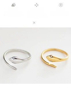Detailed macro of 18K gold plated snake rings with sparkling stone eyes and polished finish