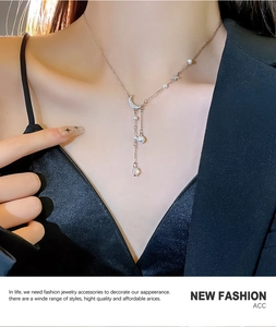 Close-up of titanium steel necklace with pearl tassels and zircon moon pendant