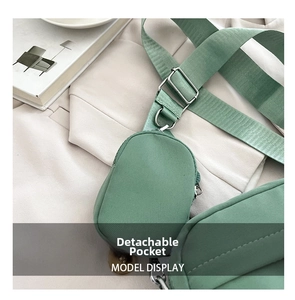 Detail of avocado green nylon crossbody bag with a detachable pouch and wide strap