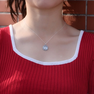 Close-up of S925 sterling silver Queen coin pendant worn on a vintage necklace