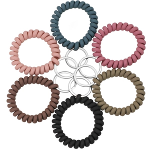 Set of 6 colorful spiral spring keychains with matte finish and metal rings on white background