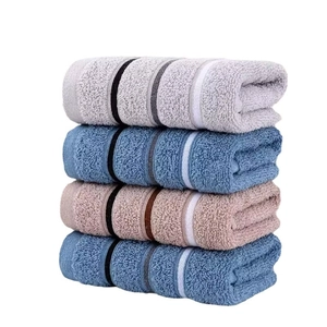 Absorbent soft cotton towels set in grey, blue, and brown tones stacked on white background