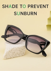 Detail of cat-eye sunglasses with gradient brown lenses on stone prop