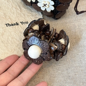 Detailed view of handcrafted ethnic wooden bead bracelet with floral petal accents